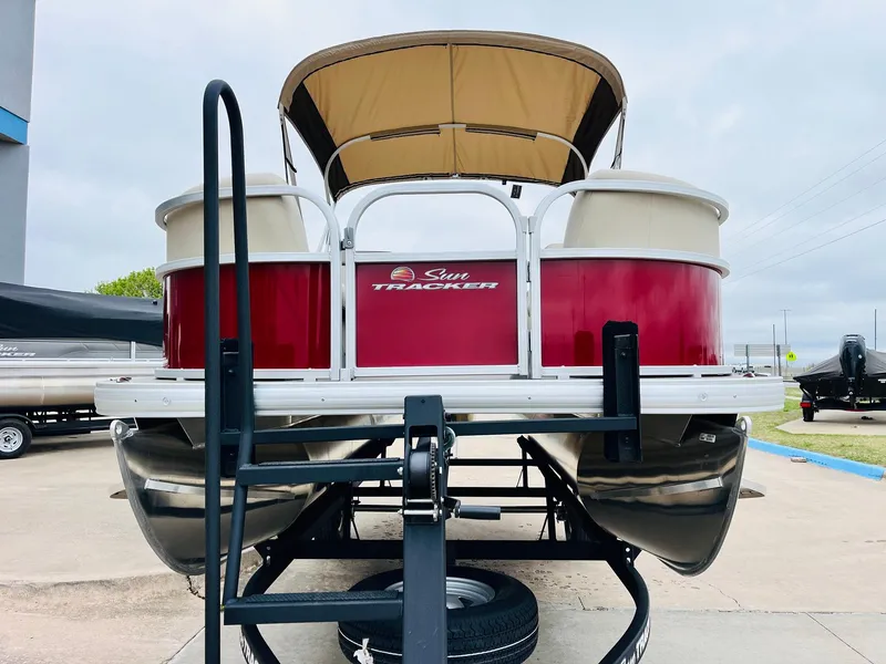 Slide: The Image of 2025 Sun Tracker Party Barge 18 DLX pontoon boat on trailer, red and white design. - 4