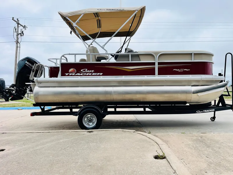 Slide: The Image of 2025 Sun Tracker Party Barge 18 DLX pontoon boat on trailer, side view. - 6