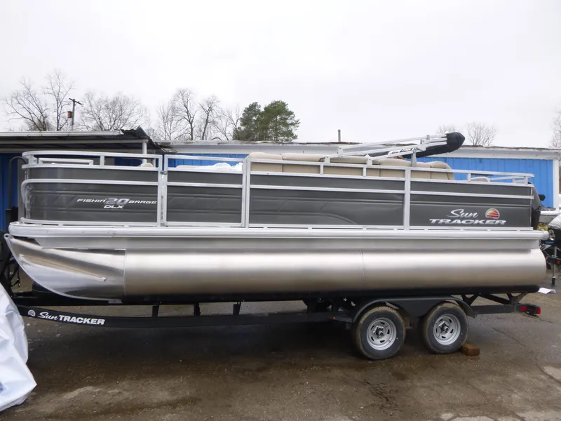 The Image of 2025 Sun Tracker Fishin' Barge 20 DLX pontoon boat on trailer, side view. - 1