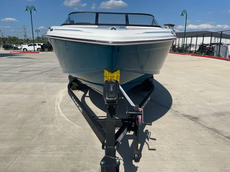Slide: The Image of 2025 Tahoe 210 S boat on trailer, parked outdoors under a clear blue sky. - 2