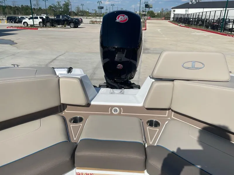 Slide: The Image of 2025 Tahoe 210 S boat interior with beige seating and outboard motor in a parking lot. - 5