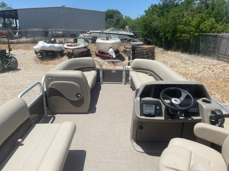 Slide: The Image of 2025 Sun Tracker Party Barge 18 DLX pontoon boat with beige seating and steering console. - 5