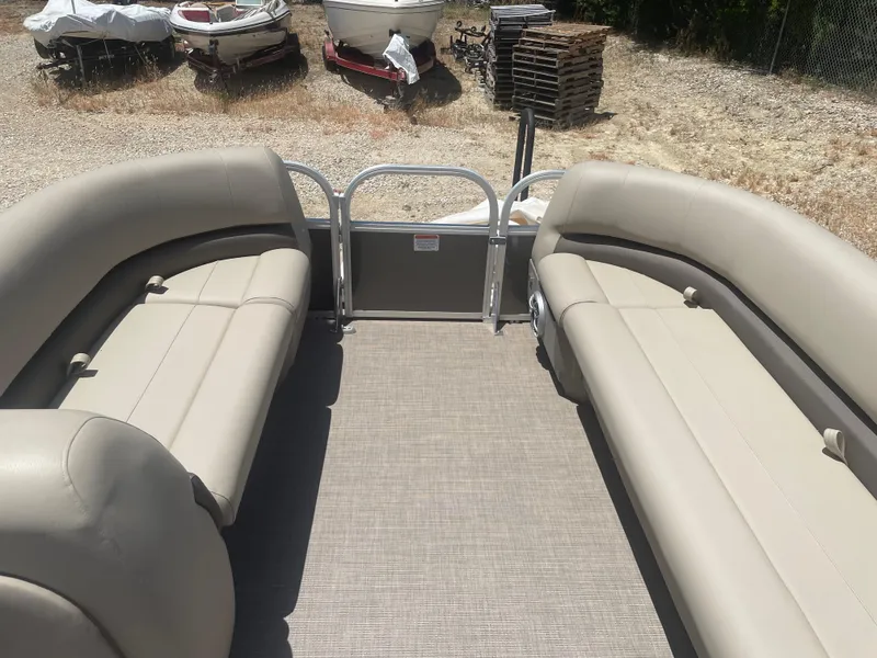 Slide: The Image of 2025 Sun Tracker Party Barge 18 DLX interior with beige seating and open deck. - 6