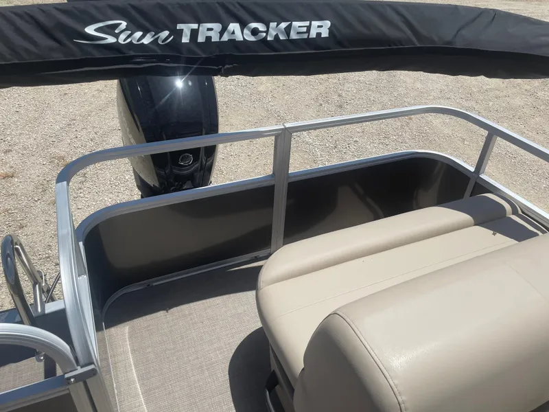 Slide: The Image of 2025 Sun Tracker Party Barge 18 DLX pontoon boat with beige seating and black canopy. - 9