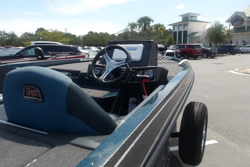 Slide: The Image of 2025 Ranger Z518 Cup-Equipped boat in parking lot, showcasing steering wheel and seating. - 10