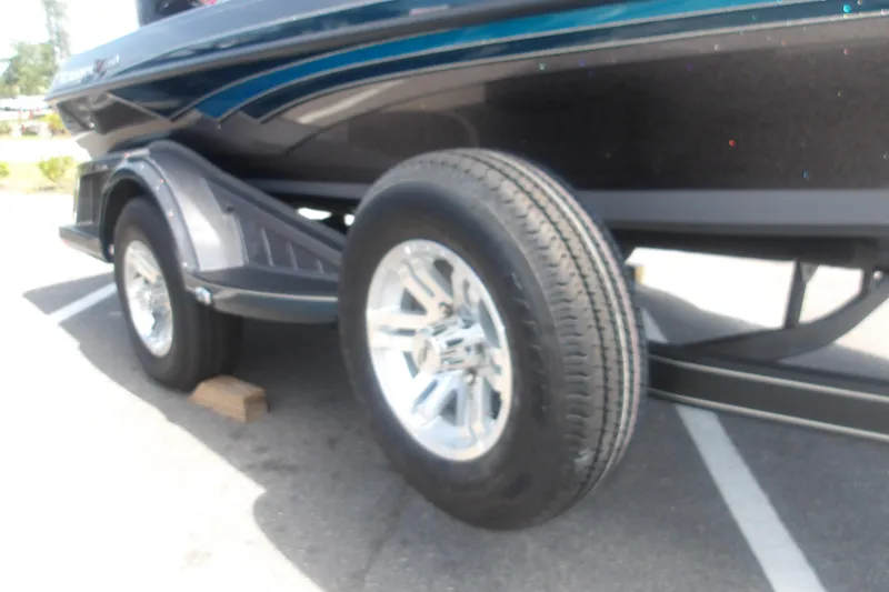 Slide: The Image of 2025 Ranger Z518 Cup-Equipped boat trailer with shiny chrome wheels in a parking lot. - 12