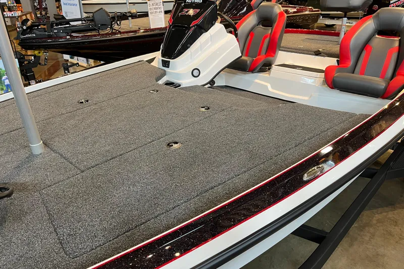 Slide: The Image of 2025 Nitro Z19 boat with gray carpeted deck and red-accented seats on display. - 6