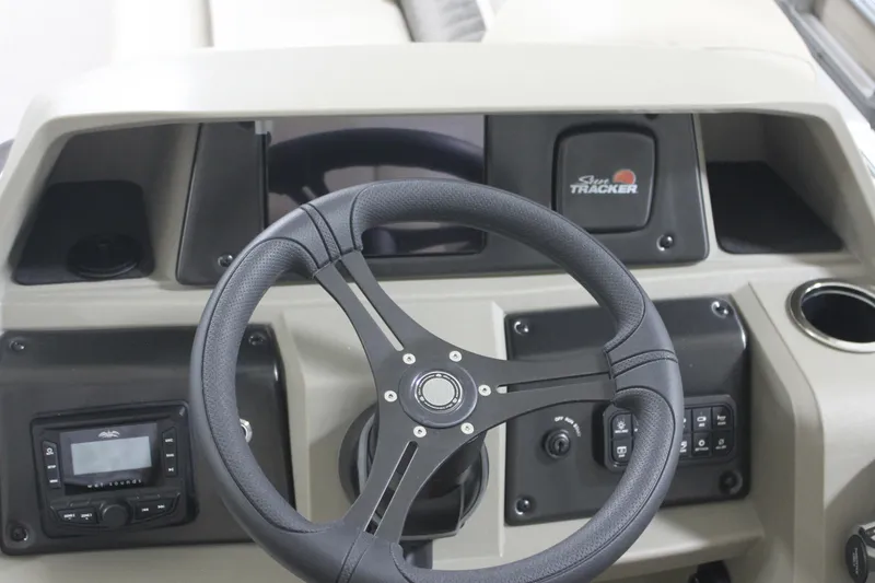 Slide: The Image of 2025 Sun Tracker Party Barge 20 DLX dashboard with steering wheel and controls. - 11