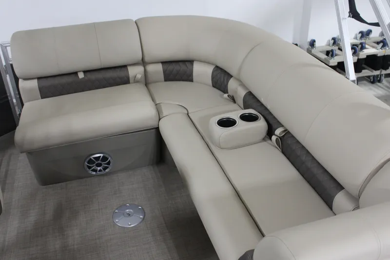Slide: The Image of 2025 Sun Tracker Party Barge 20 DLX interior with beige seating and cup holders. - 16