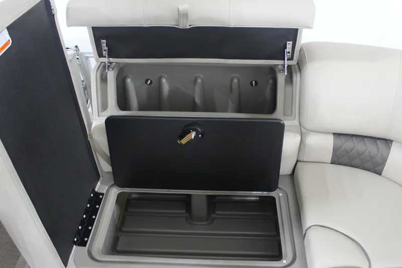 Slide: The Image of 2025 Sun Tracker Party Barge 20 DLX storage compartment with open seating and secure latch. - 19