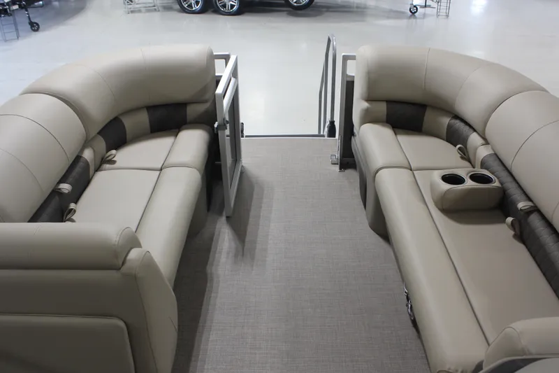 Slide: The Image of 2025 Sun Tracker Party Barge 20 DLX interior with beige seating and cup holders. - 4