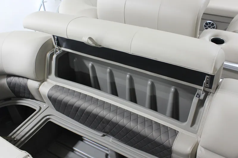Slide: The Image of 2025 Sun Tracker Party Barge 20 DLX storage compartment with cushioned seating and cup holder. - 5