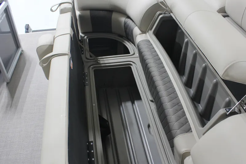 Slide: The Image of 2025 Sun Tracker Party Barge 20 DLX interior storage compartments, featuring cushioned seating. - 6