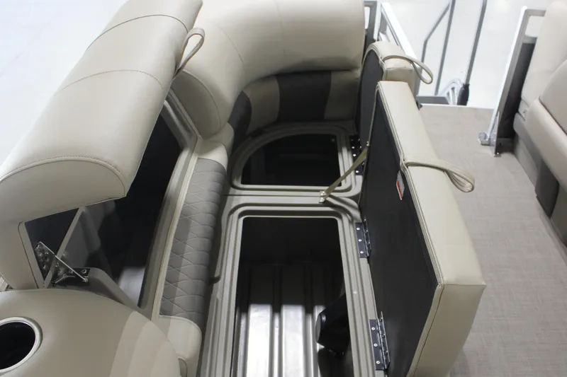Slide: The Image of 2025 Sun Tracker Party Barge 20 DLX interior storage compartments with beige seating. - 8
