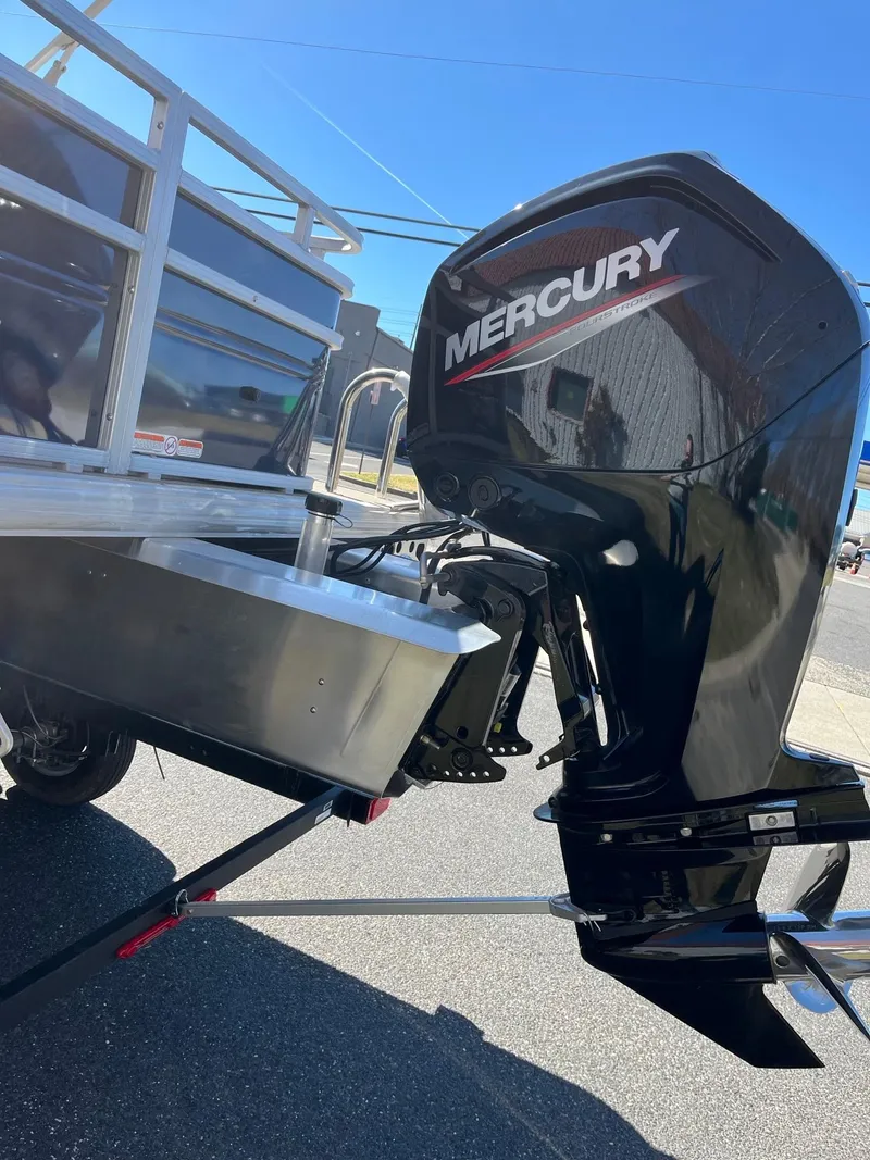 Slide: The Image of 2025 Sun Tracker Fishin' Barge 20 DLX with Mercury outboard motor on trailer. - 4