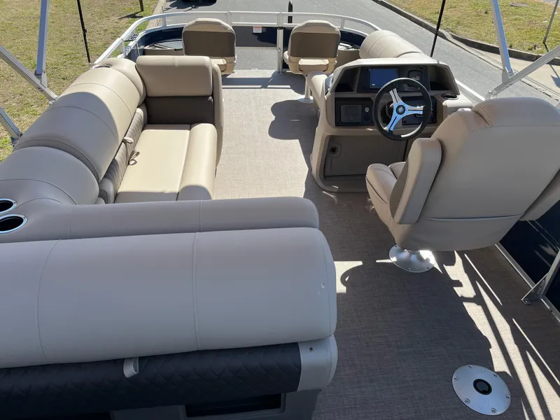 Slide: The Image of 2025 Sun Tracker Fishin' Barge 20 DLX interior with beige seating and steering console. - 9