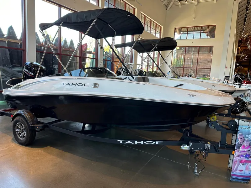 Slide: The Image of 2025 Tahoe T16 boat with canopy displayed indoors on a trailer. - 0