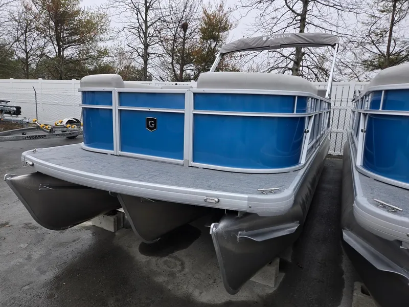 Slide: The Image of 2025 Godfrey Xperience 2286 SFLX pontoon boat with blue exterior, docked outdoors. - 2