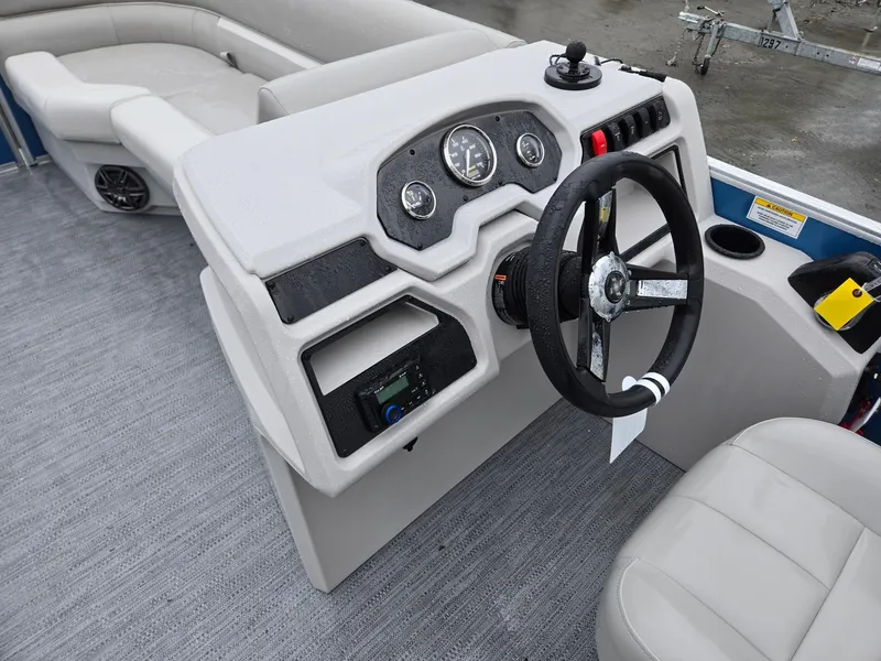 Slide: The Image of 2025 Godfrey Xperience 2286 SFLX boat interior with steering wheel and dashboard controls. - 27