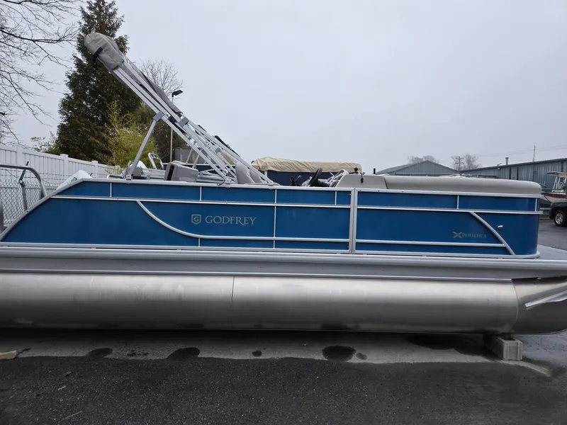 Slide: The Image of 2025 Godfrey Xperience 2286 SFLX pontoon boat, blue exterior, parked outdoors. - 3