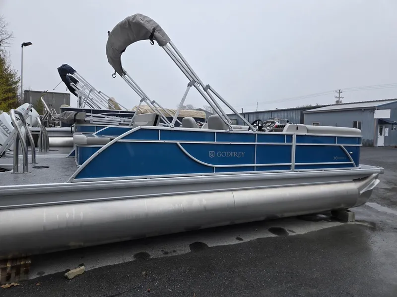 Slide: The Image of 2025 Godfrey Xperience 2286 SFLX pontoon boat, blue exterior, docked outdoors. - 4
