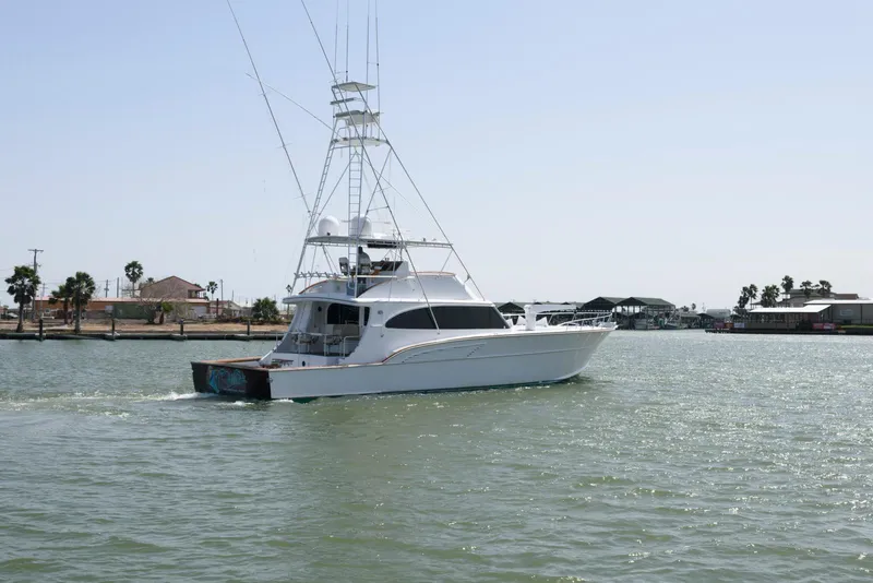 Slide: The Image of 1998 Huckins 70 Sportfish Convertible yacht cruising on a calm waterway. - 10