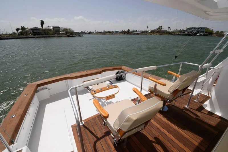 Slide: The Image of Huckins 70 Sportfish Convertible 1998 yacht deck with chairs overlooking water. - 17