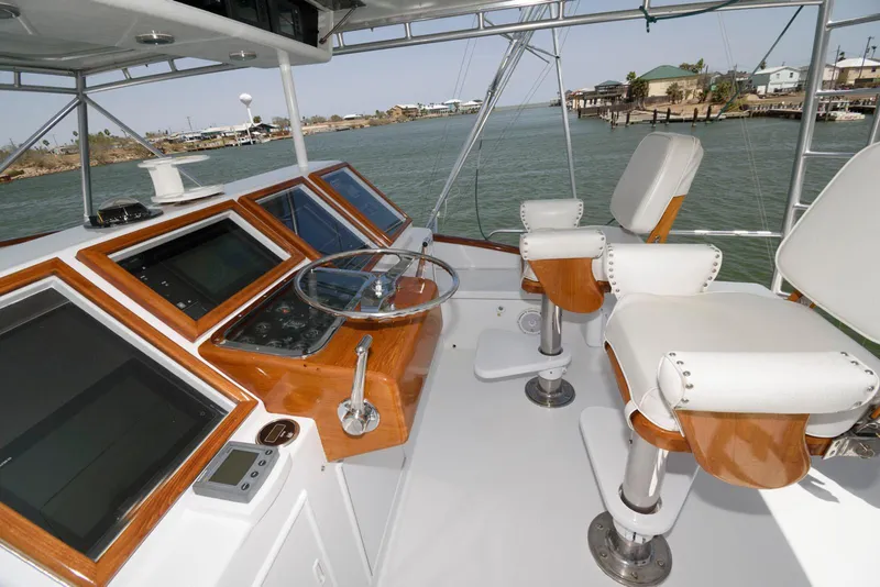 Slide: The Image of Helm of 1998 Huckins 70 Sportfish Convertible with dual captain chairs and navigation equipment. - 21