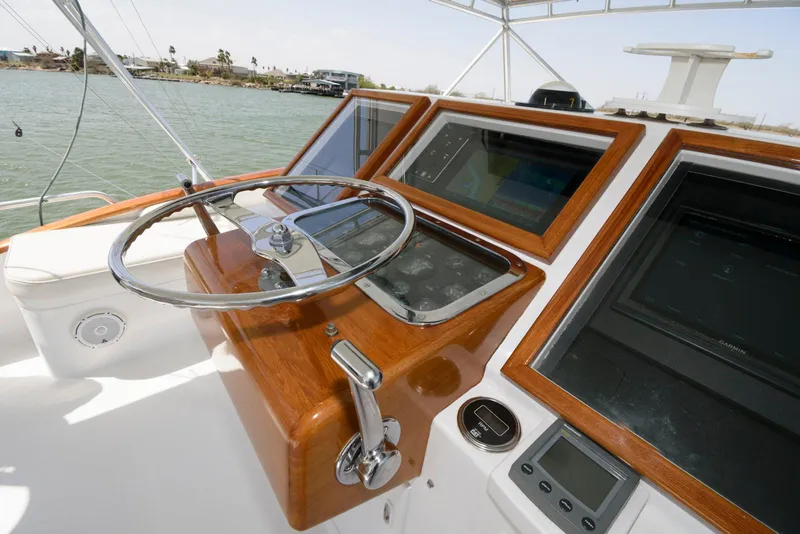 Slide: The Image of 1998 Huckins 70 Sportfish Convertible helm with wooden dashboard and modern navigation equipment. - 22