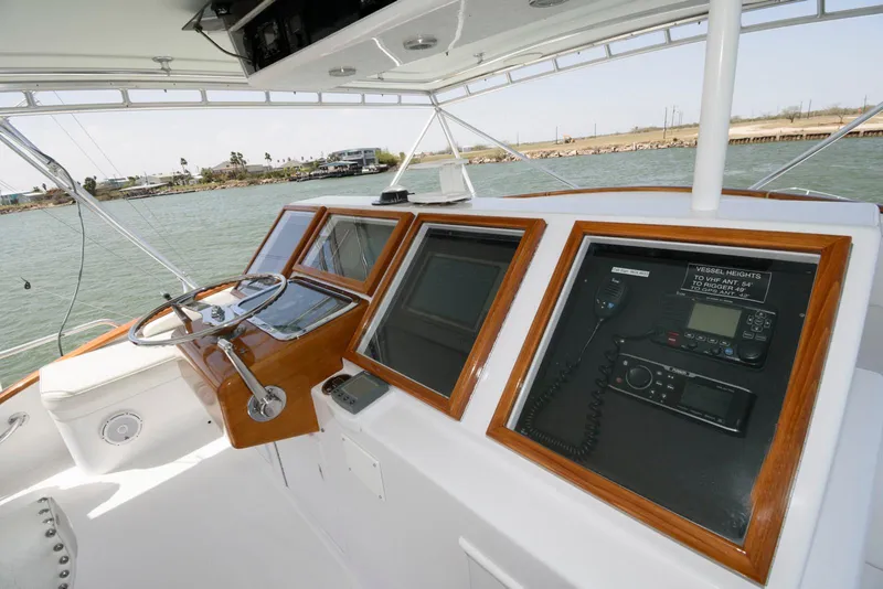 Slide: The Image of Cockpit of 1998 Huckins 70 Sportfish Convertible with navigation equipment and steering wheel. - 23