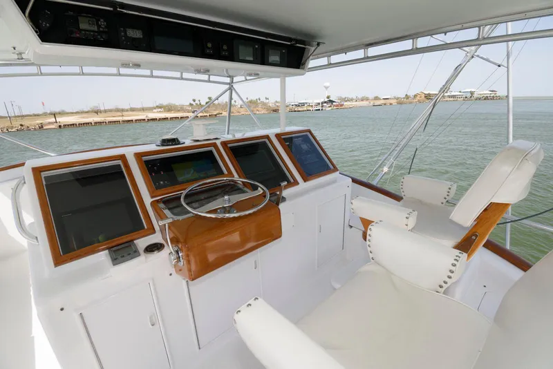 Slide: The Image of Helm of 1998 Huckins 70 Sportfish Convertible with navigation equipment and seating. - 24