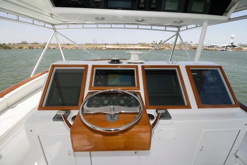 Slide: The Image of Helm of 1998 Huckins 70 Sportfish Convertible with navigation screens and steering wheel. - 25