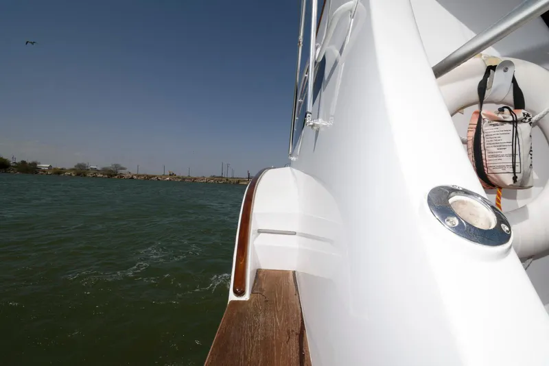 Slide: The Image of 1998 Huckins 70 Sportfish Convertible yacht on water, side view with clear sky. - 31