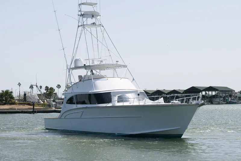 Slide: The Image of 1998 Huckins 70 Sportfish Convertible yacht cruising in a marina setting. - 4