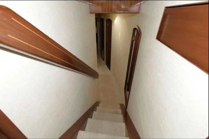 Slide: The Image of Interior staircase of 1998 Huckins 70 Sportfish Convertible yacht, featuring wooden accents. - 41