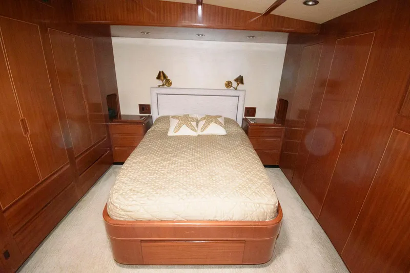 Slide: The Image of Luxurious bedroom interior of 1998 Huckins 70 Sportfish Convertible yacht with wood paneling. - 43