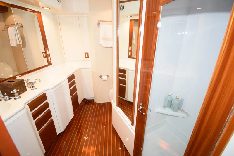 Slide: The Image of Luxurious bathroom on 1998 Huckins 70 Sportfish Convertible yacht with wood accents and modern fixtures. - 44