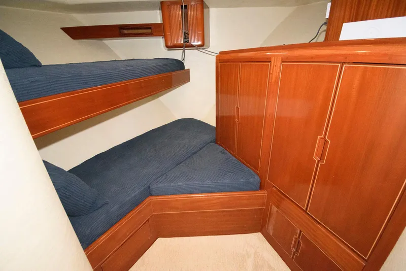 Slide: The Image of 1998 Huckins 70 Sportfish Convertible cabin with wooden bunk beds and storage cabinets. - 45