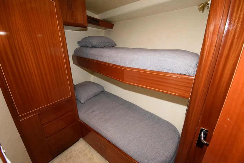 Slide: The Image of Bunk beds in 1998 Huckins 70 Sportfish Convertible yacht cabin, featuring wooden cabinetry. - 47
