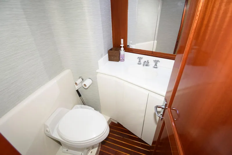 Slide: The Image of Bathroom interior of 1998 Huckins 70 Sportfish Convertible yacht, featuring toilet and sink. - 48