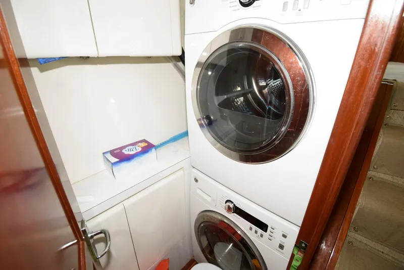 Slide: The Image of Laundry area with stacked washer and dryer in 1998 Huckins 70 Sportfish Convertible. - 49