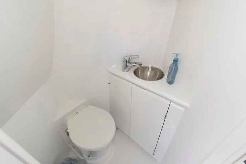 Slide: The Image of Compact bathroom in 1998 Huckins 70 Sportfish Convertible yacht with toilet and sink. - 50