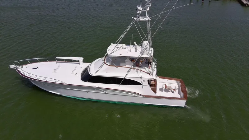 Slide: The Image of 1998 Huckins 70 Sportfish Convertible yacht cruising on green water. - 6