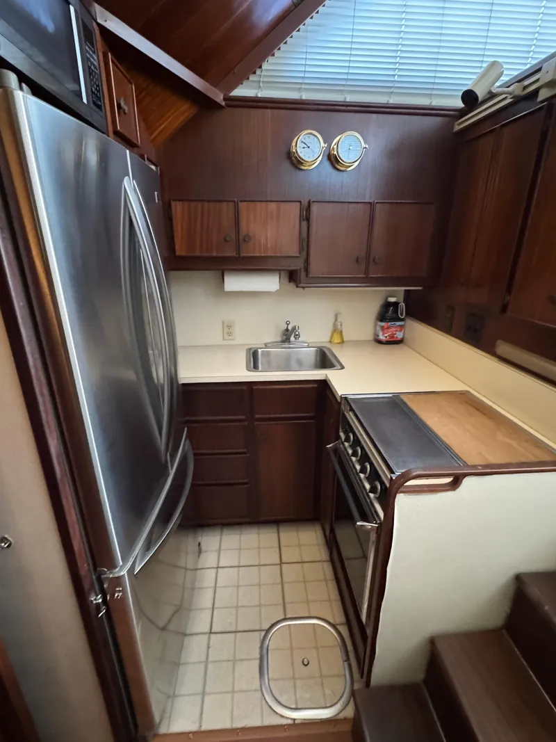 Slide: The Image of 1984 Hatteras 46 Convertible yacht kitchen with wood cabinets and stainless steel appliances. - 13