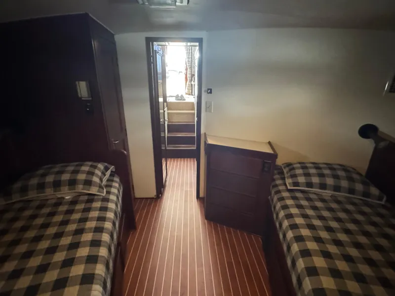 Slide: The Image of Interior cabin of 1984 Hatteras 46 Convertible with twin beds and wooden flooring. - 14