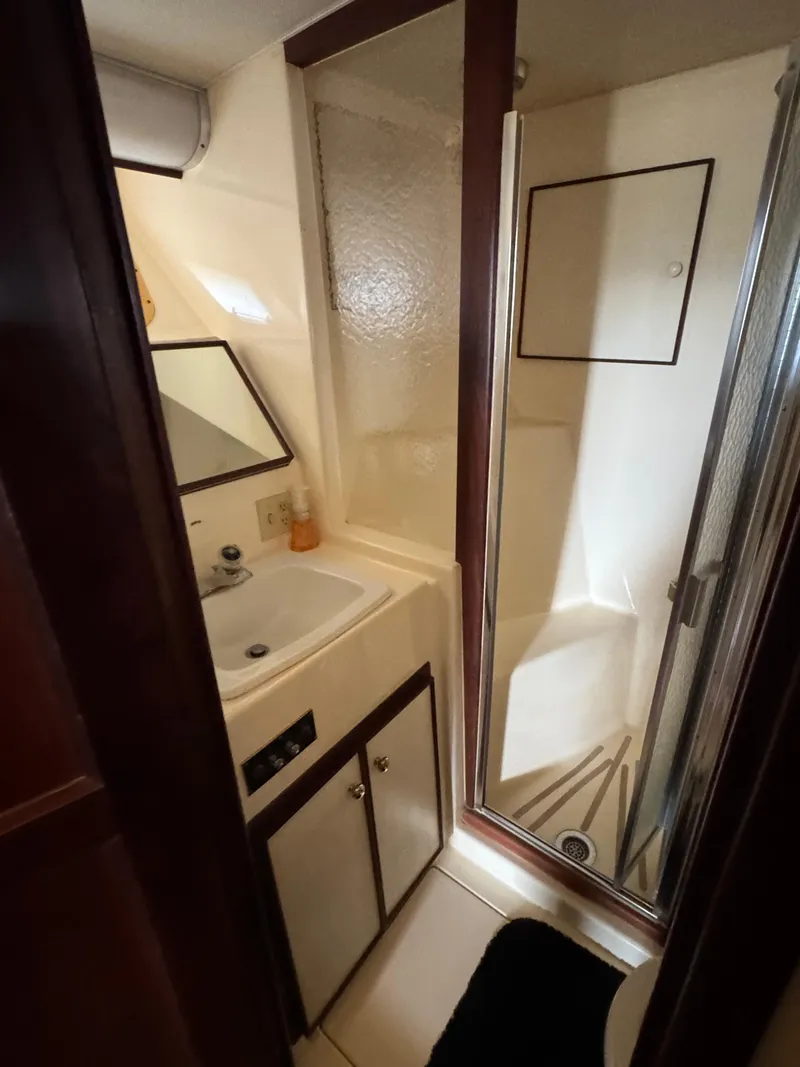 Slide: The Image of 1984 Hatteras 46 Convertible yacht bathroom with sink, mirror, and shower. - 16