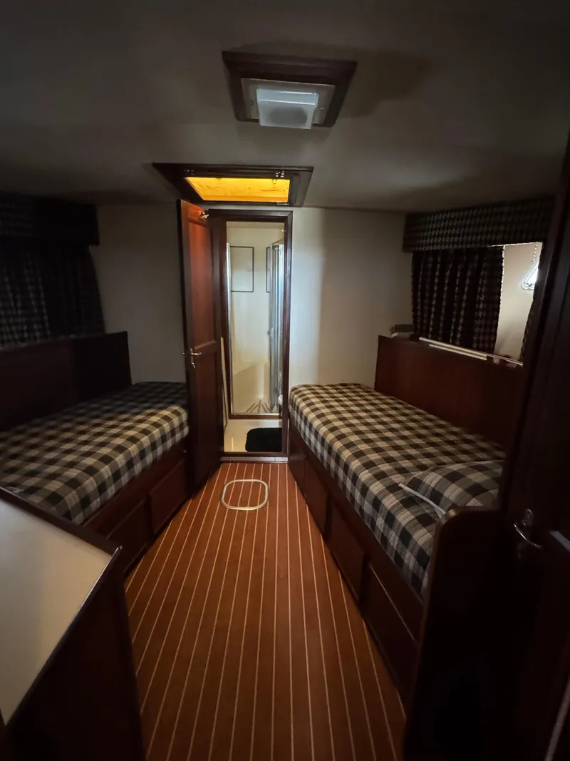 Slide: The Image of Interior of 1984 Hatteras 46 Convertible yacht with twin beds and wood flooring. - 17