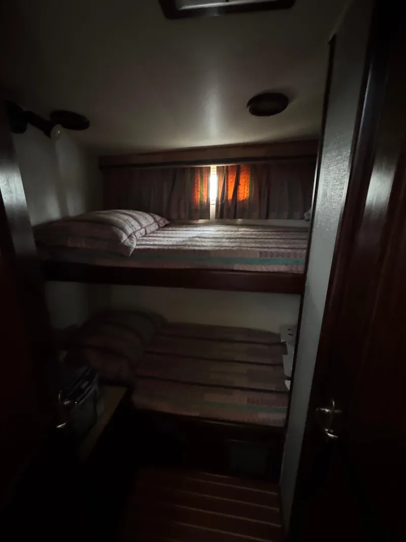 Slide: The Image of Bunk beds in 1984 Hatteras 46 Convertible yacht cabin with dim lighting. - 18