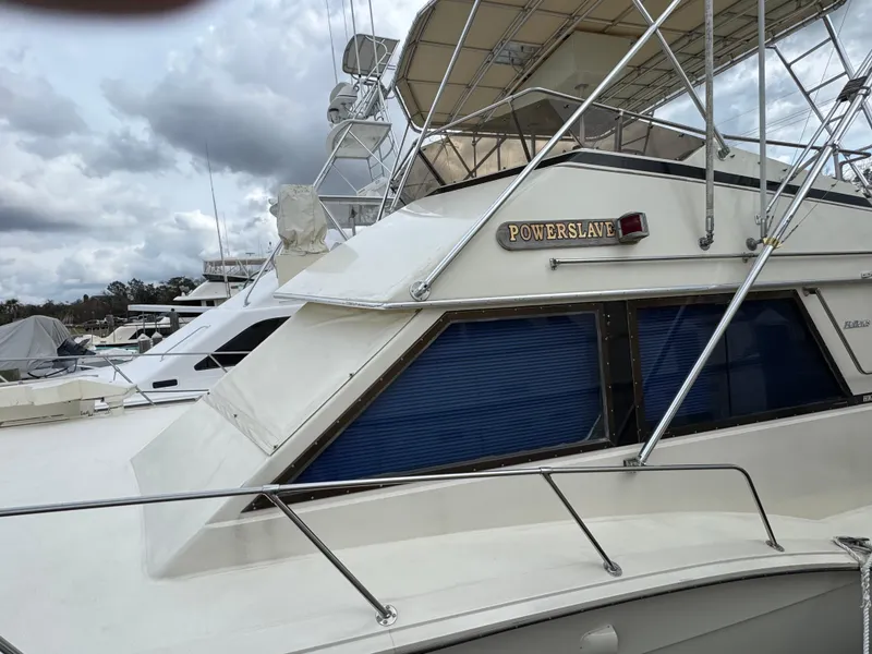 Slide: The Image of 1984 Hatteras 46 Convertible yacht docked, featuring sleek design and blue window shades. - 21