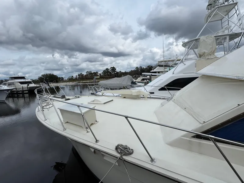 Slide: The Image of 1984 Hatteras 46 Convertible yacht docked under cloudy skies. - 22